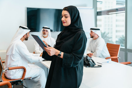 Group of middle-eastern corporate business people wearing traditional emirati clothes meeting in the office in Dubai - Business team working and brainstorming in the UAEの写真素材