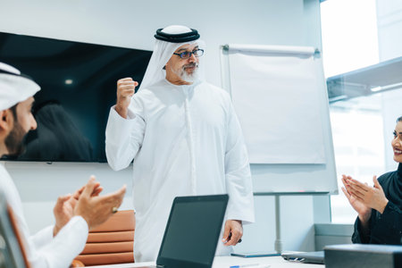 Group of middle-eastern corporate business people wearing traditional emirati clothes meeting in the...
