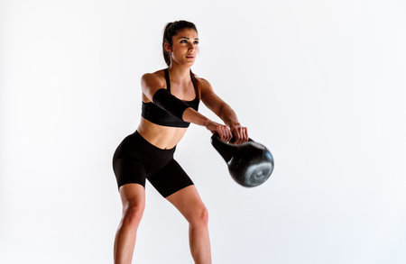 Young female athlete training in a gym using sport equipment. Fit woman working out. Concept about fitness, wellness and sport preparation.の写真素材