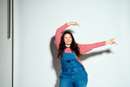 Plus size woman model posing in studio and having fun. Shots taken on white background and direct hard lightの写真素材