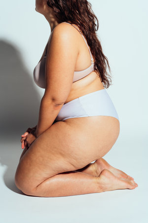 Plus size woman posing in studio in lingerie. Model on white background. Hard light studio shotの写真素材