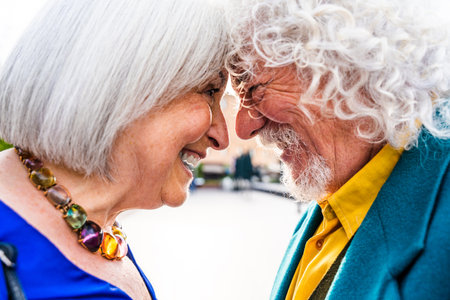 Senior couple of old people dating outdoors - Married elderly man and woman in love spending time together - Grandparents having fun strolling in the cityの写真素材