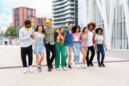 Happy playful multiethnic group of young friends bonding outdoors - Multiracial millennials students meeting in the city, concepts of youth, people lifestyle, diversity, teenage and urban lifeの写真素材