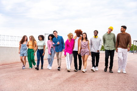 Happy playful multiethnic group of young friends bonding outdoors - Multiracial millennials students...