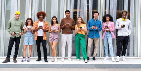 Happy playful multiethnic group of young friends bonding outdoors - Multiracial millennials students meeting in the city, concepts of youth, people lifestyle, diversity, teenage and urban lifeの写真素材