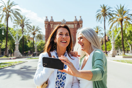 Beautiful senior women bonding outdoors in the city - Attractive cheerful mature female friends having fun, shopping and bonding, concepts about elderly lifestyleの写真素材