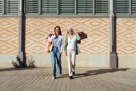 Beautiful senior women bonding outdoors in the city - Attractive cheerful mature female friends having fun, shopping and bonding, concepts about elderly lifestyleの写真素材