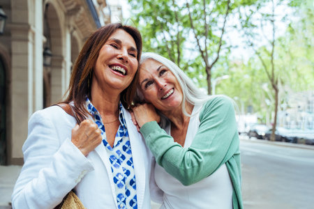 Beautiful senior women bonding outdoors in the city - Attractive cheerful mature female friends having fun, shopping and bonding, concepts about elderly lifestyleの写真素材