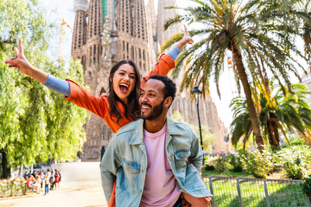 Multiracial beautiful happy couple of lovers dating at Sagrada Familia, Barcelona - Multiethnic tourists traveling in Europe and visiting a city in Spain, concepts about tourism and people lifestyleの写真素材
