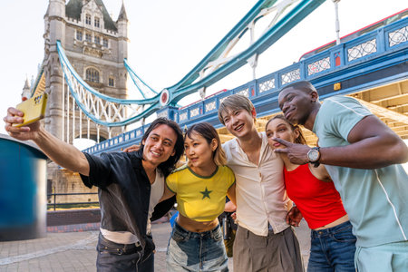 Multiracial group of happy young friends bonding in London city - Multiethnic teens students meeting and having fun in Tower Bridge area, UK - Concepts about youth lifestyle, travel and tourismの写真素材