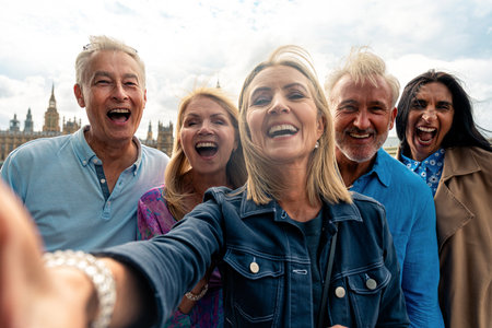 Group of old friends spending time together in the main parts of London, visiting the Westminster area and St. james park. Old buddies reunion. Concept about third age and seniorityの写真素材