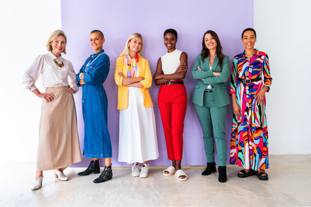 Group of beautiful confident businesswomen meeting in the office - Multiethinc female creative team brainstorming at work - Diverse colleagues working together in workshop in a co-working spaceの写真素材