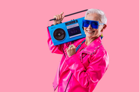 Happy and funny senior old woman wearing fashinable clothing on colorful background- Modern cool...