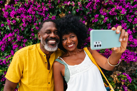 Beautiful mature black couple of lovers dating at the seaside - Married african middle-aged couple bonding and having fun outdoors, concepts about relationship, lifestyle and quality of lifeの写真素材