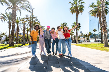 Multiethnic group of young happy friends hanging out in the city - Multiracial group of students meeting and having fun outdoors, concepts about youth, teenage, diversity and lifestyleの写真素材