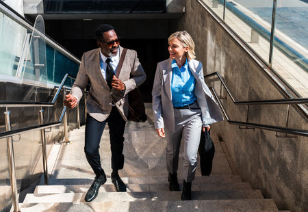 Mature black businessman and middle aged businesswoman traveling for work - Multiethnic business team going to work at officeの写真素材