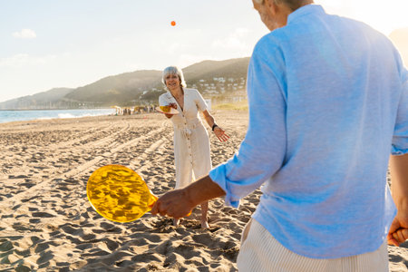 Beautiful happy senior couple dating at the seaside during summertime - Mature married couple in love bonding outdoors at the beach, concepts about elderly lifestyle, relationship and quality of lifeの写真素材