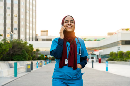 Beautiful arab nurse wearing hijab portrait at the city hospital - Middle eastern adult female working in healthcare clinicの写真素材