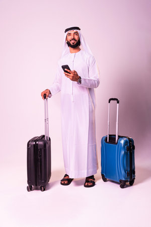 Arab businessman wearing emirates kandura portrait in studio in Dubai - Handsome middle eastern male adult posing on cut-out background - Muslim bearded man with traditional emirates clothingの写真素材