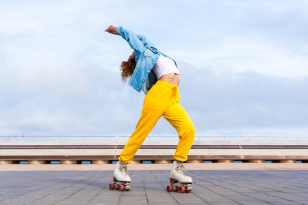 Beautiful red haired young woman with rollerskates having fun outdoors - Pretty female teenager girl with unique style riding on roller skates in the cityの写真素材