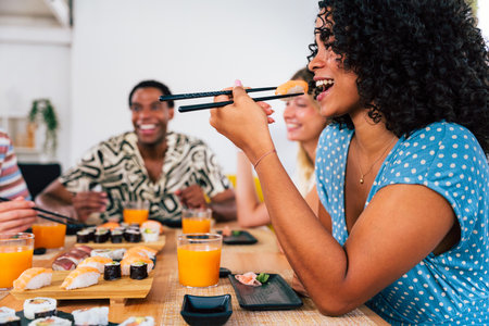 Multiethnic group of young friends meeting at home and eating sushi - Multiracial happy people bonding while having lunchの写真素材