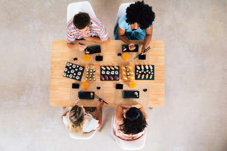 Multiethnic group of young friends meeting at home and eating sushi - Multiracial happy people...