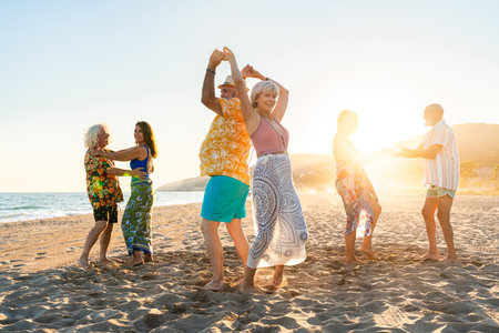 Happy group of senior friends bonding at the beach during summertime - Cheerful old and mature people having fun at the sea on summer vacation, elderly lifestyle conceptsの写真素材
