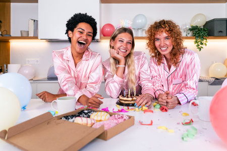 Multiethnic group of young female friends having pajamas party at home - Happy cheerful best girlfriends bonding and having fun at homeの写真素材
