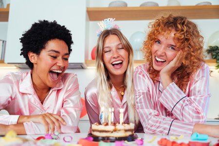 Multiethnic group of young female friends having pajamas party at home - Happy cheerful best girlfriends bonding and having fun at homeの写真素材