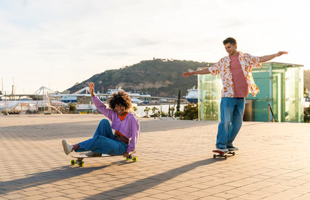 Young multiethnic modern couple with skateboards dating outdoors - Two friends having fun skating...