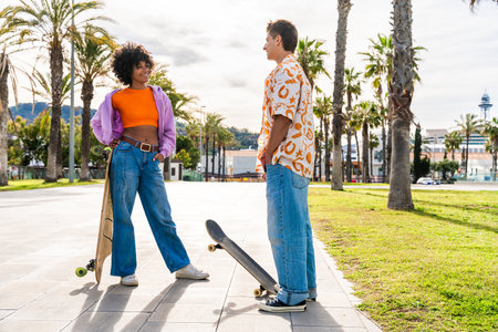 Young multiethnic modern couple with skateboards dating outdoors - Two friends having fun skating...