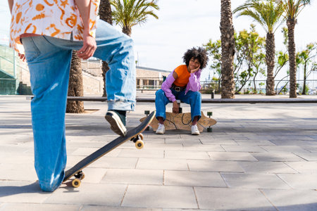 Young multiethnic modern couple with skateboards dating outdoors - Two friends having fun skating around city urban areas, concepts about youth, diversity, green transportation and mobilityの写真素材