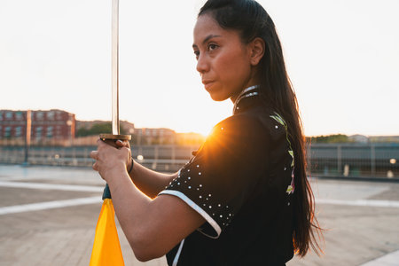 Chinese young woman practicing wushu kung fu with weapons outdoor. Young girl training martial arts...