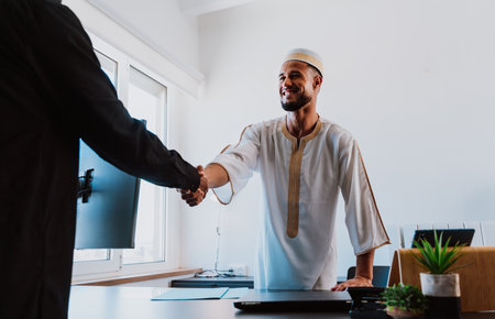 Moroccan Business man in the office. Young business man with traditional outfit working in his office. Salesman speaking with his client.の写真素材