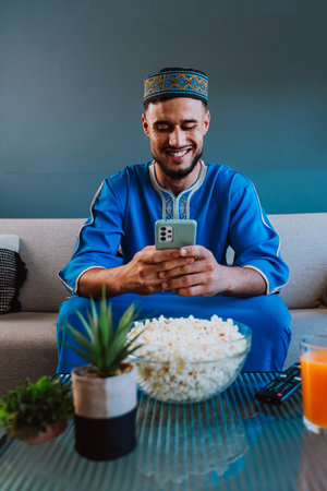 Moroccan guy with traditional outfit eating popcorn.の写真素材