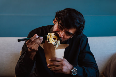 Man with traditional outfit eating noodles.