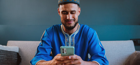 Moroccan guy with traditional outfit using smartphone and taking selfies.の写真素材