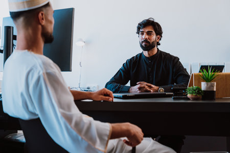 Pakistani Business man in the office. Young business man with traditional outfit working in his office. Salesman speaking with his client.の写真素材