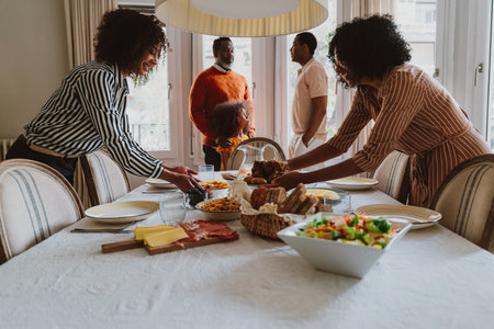 Storytelling image of a Family reunited at parents house for lunch on the holidays. Family members celebrating at home eating good food, sharing love and positive emotions.の写真素材