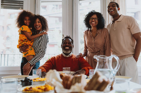 Storytelling image of a Family reunited at parents house for lunch on the holidays. Family members celebrating at home eating good food, sharing love and positive emotions.の写真素材