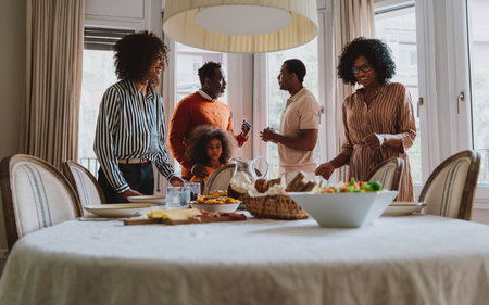 Storytelling image of a Family reunited at parents house for lunch on the holidays. Family members celebrating at home eating good food, sharing love and positive emotions.の写真素材