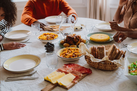 Storytelling image of a Family reunited at parents house for lunch on the holidays. Family members celebrating at home eating good food, sharing love and positive emotions.の写真素材