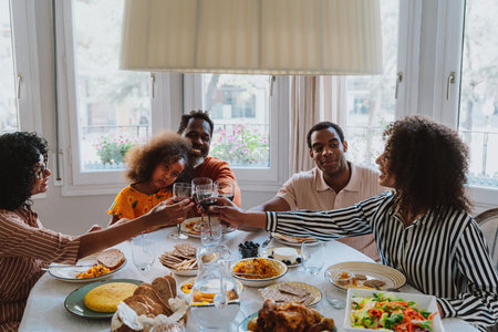 Storytelling image of a Family reunited at parents house for lunch on the holidays. Family members celebrating at home eating good food, sharing love and positive emotions.の写真素材