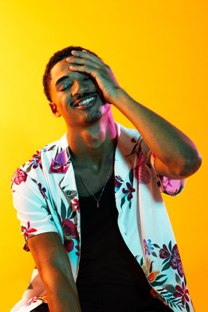 Young man portrait in studio on colorful background - Black young male with stylish attire posing,...