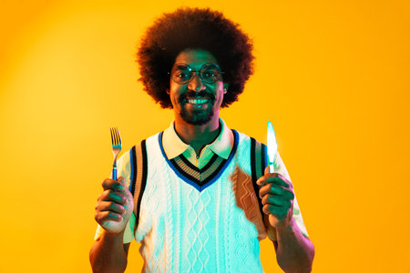 African man portrait in studio on colorful background - Cool black young male with stylish attire posing, creative colored lightingの写真素材