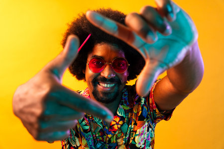 African man portrait in studio on colorful background - Cool black young male with stylish attire posing, creative colored lightingの写真素材