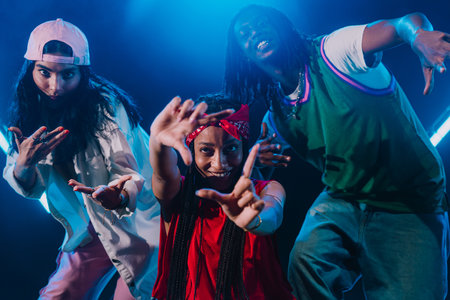 Group of hip hop dancers dancing together in a moody studio with tube neon lights.の写真素材