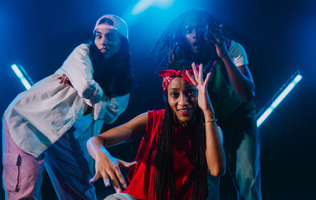 Group of hip hop dancers dancing together in a moody studio with tube neon lights.の写真素材