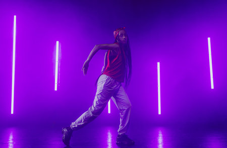 Hip hop dancer dancing in a cool studio with neon lights.