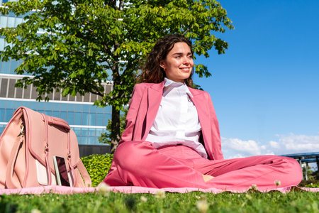 Beautiful young businesswoman wearing colorful elegant suit sitting in the city - Cheerful caucasian woman going to work at the officeの写真素材
